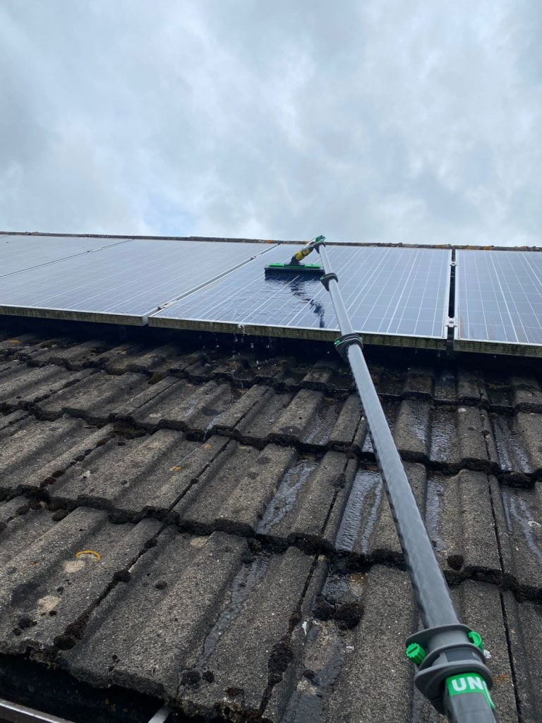 Using a window cleaning pole to clean solar panels with pure water