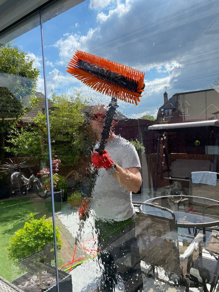 Window cleaning where you can see the pure water running down the glass and the soft brush splayed out on the glass